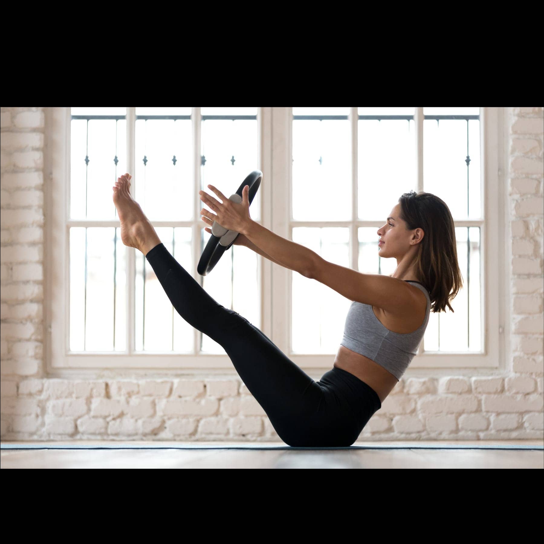 A person doing gentle, supported core work with a light prop