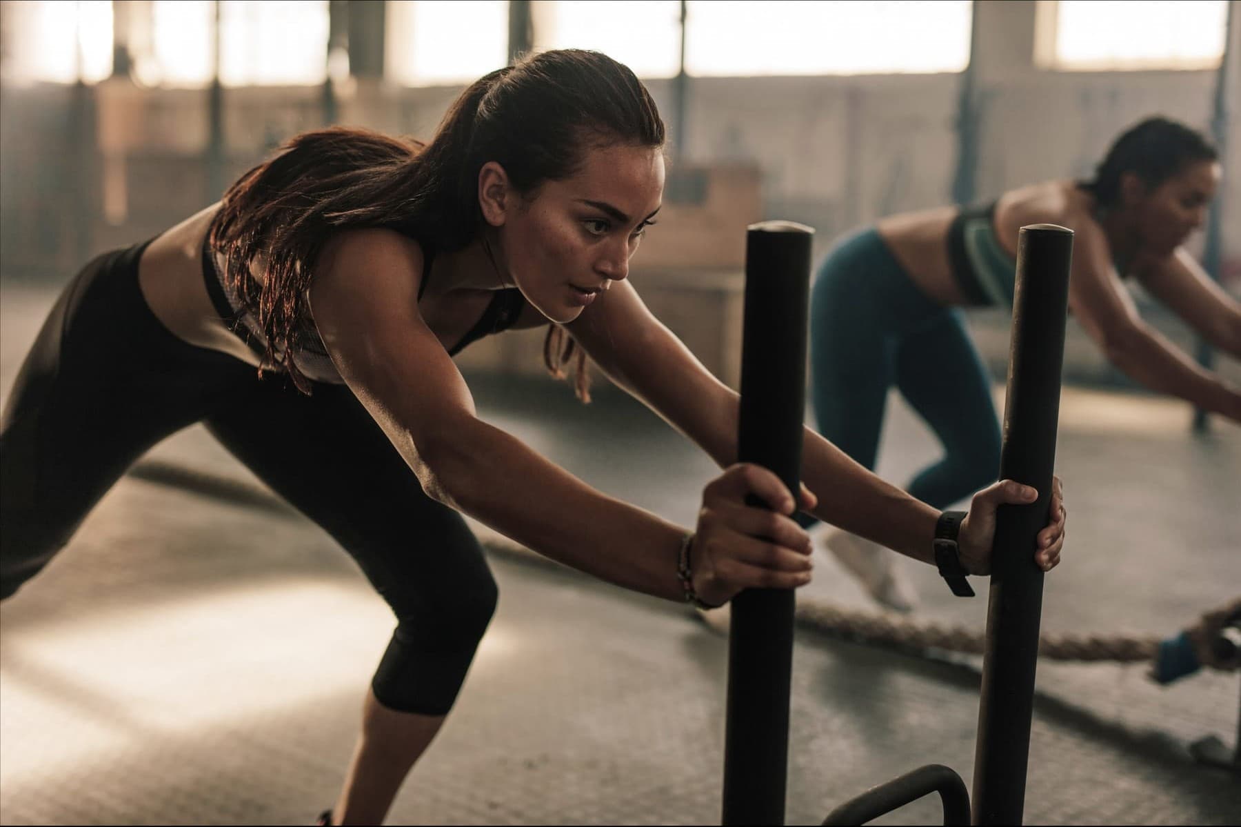 A person driving a sled, honest strength work at a steady effort