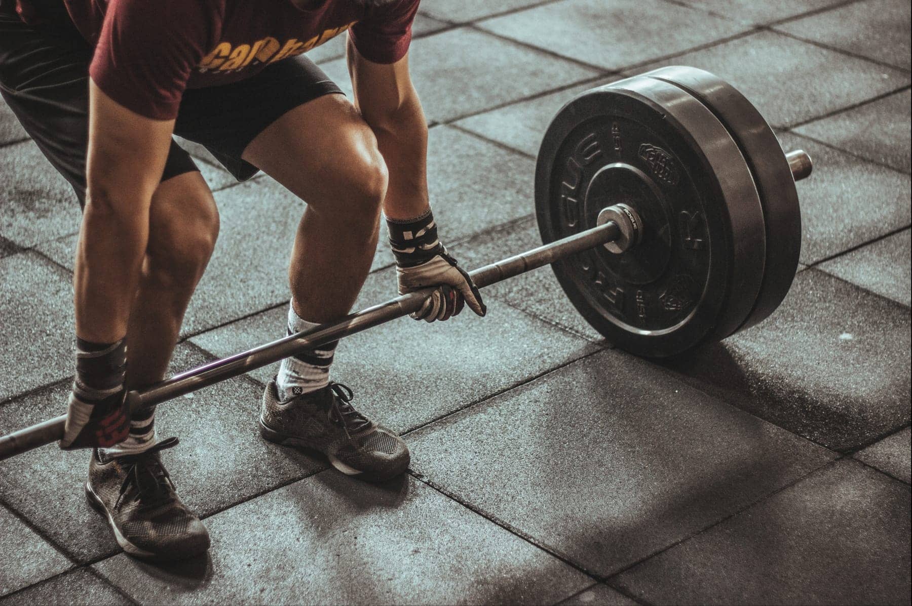 A lifter holding a loaded barbell steady, the kind of strength work that keeps muscle on while weight comes off